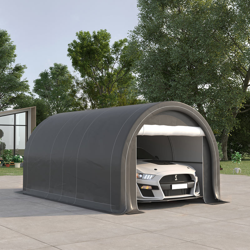 Portable garage shed with a car inside, surrounded by trees and a clear sky.