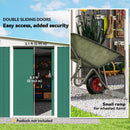 Storage shed with double sliding doors and a wheelbarrow with a small ramp.