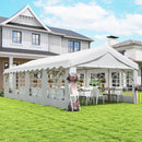 13 x 26 White outdoor canopy tent set up in a backyard with tables and chairs underneath, in front of a house.