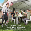 People enjoying a meal under a large white tent with balloons, suitable for various occasions.