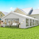 20 x 40 White party tent set up outdoors with tables and chairs under a clear blue sky.