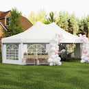 White decagonal party tent with pink and white balloon arches in a backyard setting.