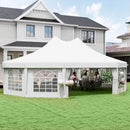 White decagonal outdoor canopy tent set up on a grassy area in front of a house.