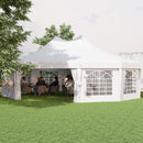White outdoor party tent with people sitting inside on a grassy area
