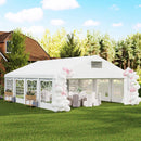 20 x 26 White party tent with balloon arches on a grassy lawn with trees in the background