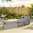 Outdoor patio with a propane fire pit table, surrounded by plants and a wooden fence.