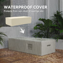 Waterproof cover protecting a rectangular fire table from rain with plants around.