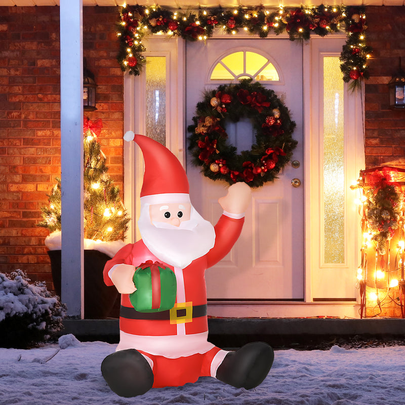 Inflatable Santa Claus figure in front of a decorated house with wreaths and lights.