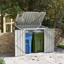 Outdoor trash bin storage shed with blue and green bins in a garden setting.