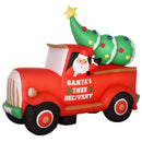 Large Christmas inflatable display of a red truck with Santa and a Christmas tree on a white background