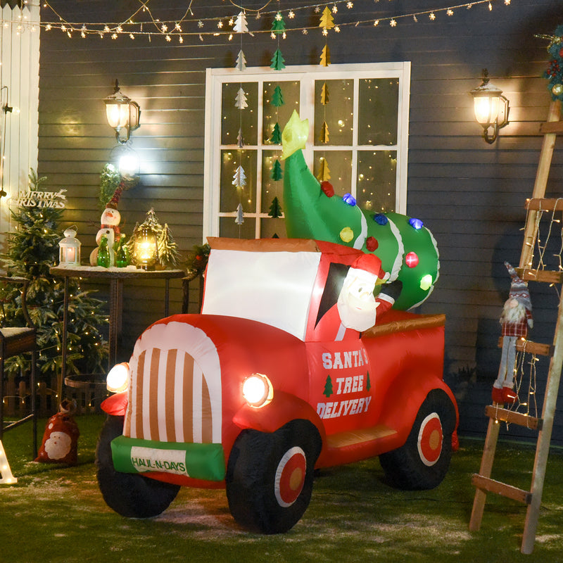 Large Christmas inflatable display, Santa Tree Delivery truck decoration in a festive outdoor setting with lights and decorations.