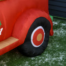 Close-up of a red inflatable slide with a black wheel on grass