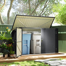 Outdoor storage shed with open door in a garden setting. Garbage and recycling bins protected inside. 