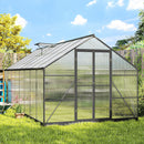 8 x 16 Greenhouse with transparent panels and black frames in a garden setting