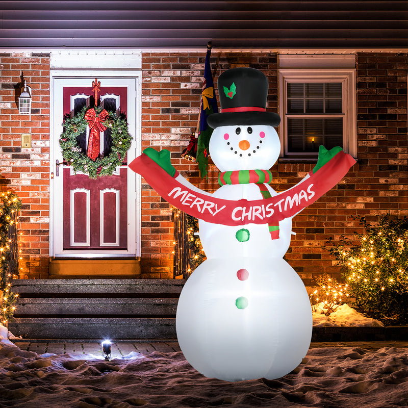 Inflatable snowman with a 'Merry Christmas' scarf in front of a brick house with a wreath on the door.