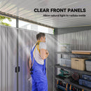 Person in blue overalls standing inside a storage shed with clear front panels.