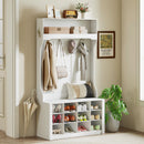 White hall tree bench with shelf, shoes cubbies, coat rack hooks, and decorative items in a room.