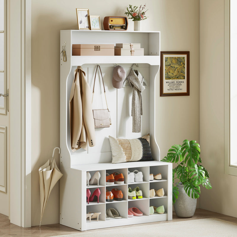 White hall tree bench with shelf, shoes cubbies, coat rack hooks, and decorative items in a room.