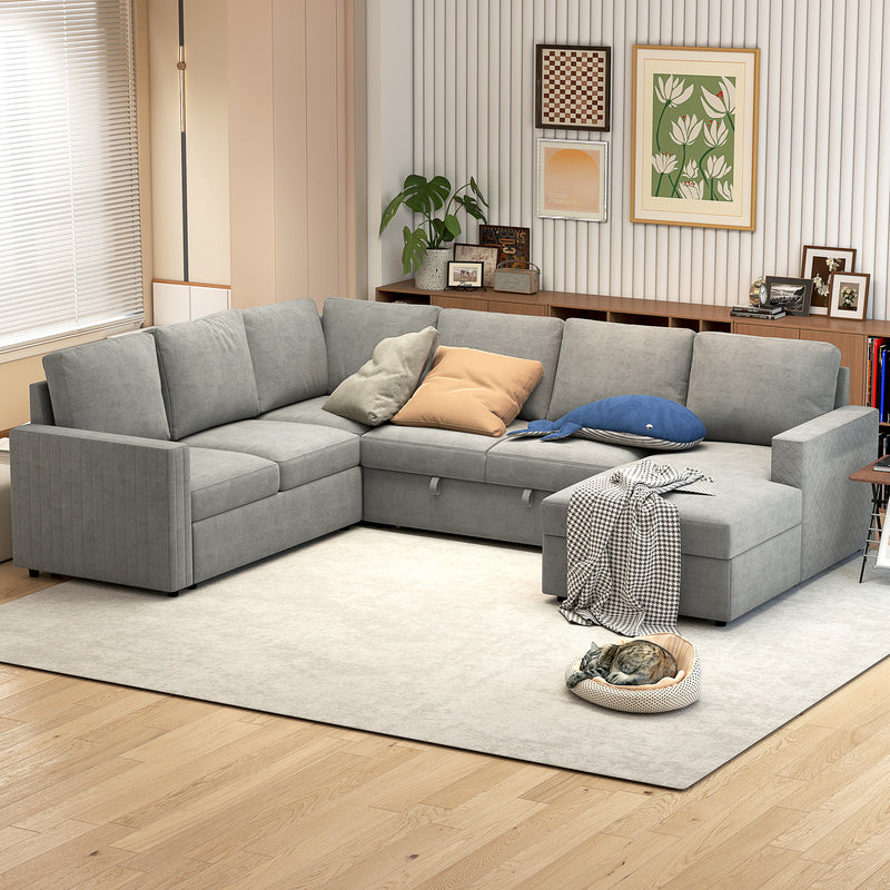 Gray sectional sleeper sofa in a living room with decorative pillows and a rug.