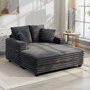 Oversized Chaise Lounge Comfy Chair with Grey Microfibre Corduroy Upholsteryin the middle of a living room setting. 