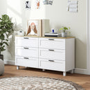 White dresser with wooden top in a room with decor elements.