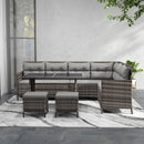 Outdoor patio furniture set with grey cushions. A sectional sofa and tables on a patio.