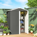 Small metal storage shed grey with plants and garden items on a sunny day