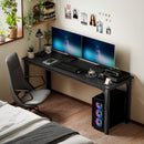 Modern bedroom with a black desk featuring two computer monitors, a chair, and decorative elements.