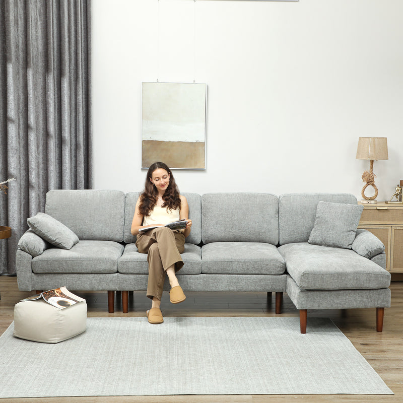 Woman sitting on light grey sectional sofa with chaise lounge and reading a book. 