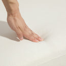 Hand touching a textured white surface