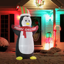 Giant Inflatable Christmas display penguin with a 'Merry Christmas' scarf in front of a decorated house.