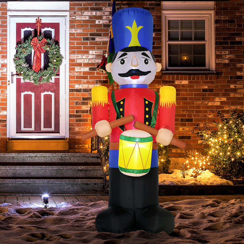 Inflatable Christmas display nutcracker decoration in front of a brick house with Christmas lights.