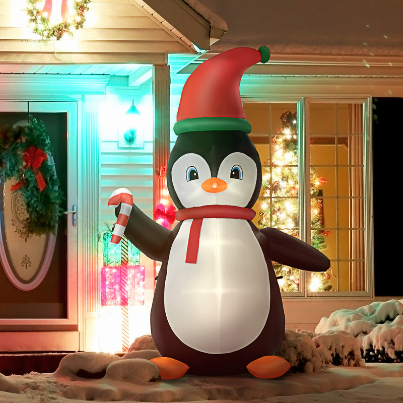 Inflatable penguin Christmas display with built-in LED with a Santa hat in front of a decorated house.