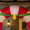 Decorative arch with red and white stripes and a yellow object, hanging above a wooden structure with a light fixture.
