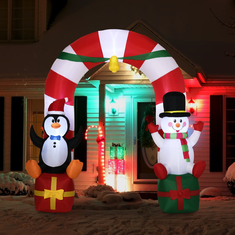 Inflatable Christmas arch with penguin and snowman decorations in front of a house.