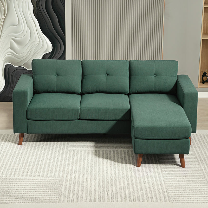 Green sectional sofa in a room with abstract wall art and a rug.