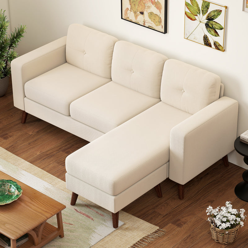 Cream white sectional sofa in a living room setting with wooden coffee table and decorative elements.