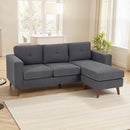 Gray sectional sofa with corduroy fabric in a living room setting with a rug and plant.