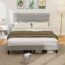 Gray upholstered bed with white bedding and a brown blanket in a bedroom setting.