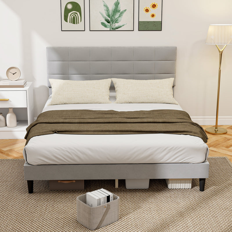 Gray upholstered bed with white bedding and a brown blanket in a bedroom setting.