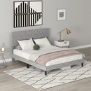 Gray upholstered bed in a bedroom setting with a lamp and decor items.