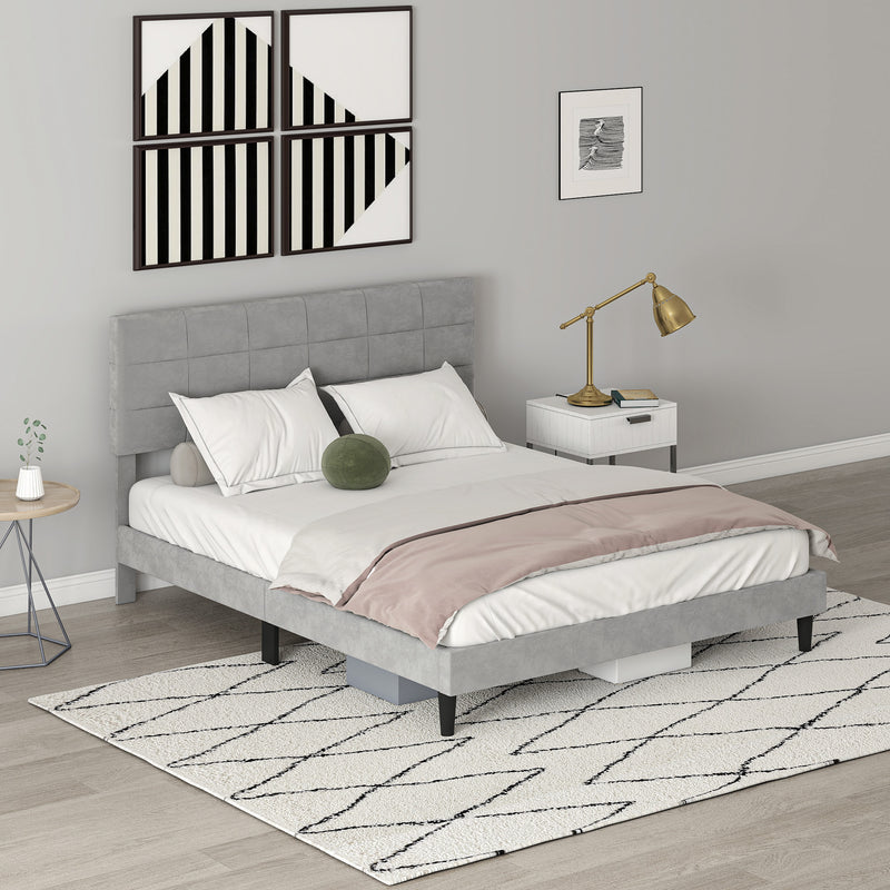 Gray upholstered bed in a bedroom setting with a lamp and decor items.