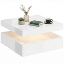 White two-tiered coffee table with decorative items on a white background