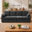 A dark gray fabric sleeper sofa in a modern, warm-toned living room setting with a wooden coffee table, potted plants, and wall decor.
