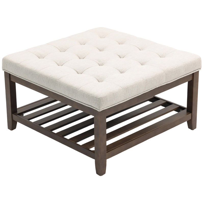 Square ottoman with tufted white cushion and wooden frame on a white background