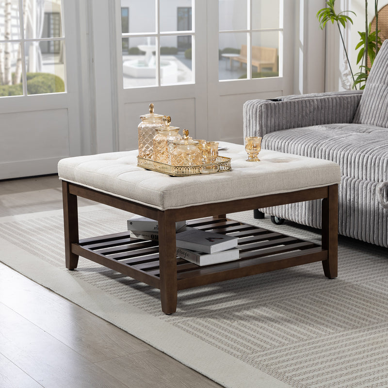 Tufted Upholstered Coffee table with shelf displayed with decorative items in a living room setting