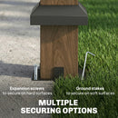 Wooden post with black top and ground stakes on grass and concrete, featuring text about securing options.