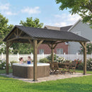 Wooden hard top gazebo over a hot tub with people sitting inside, surrounded by a garden and house.
