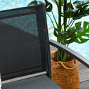 Black outdoor chair with a plant in a woven basket on a patio