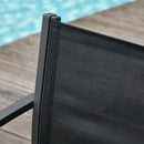 Close-up of a black mesh screen against a wooden deck with a pool in the background
